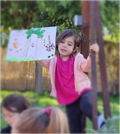 Une jeune stagiaire présente son dessin en plein air