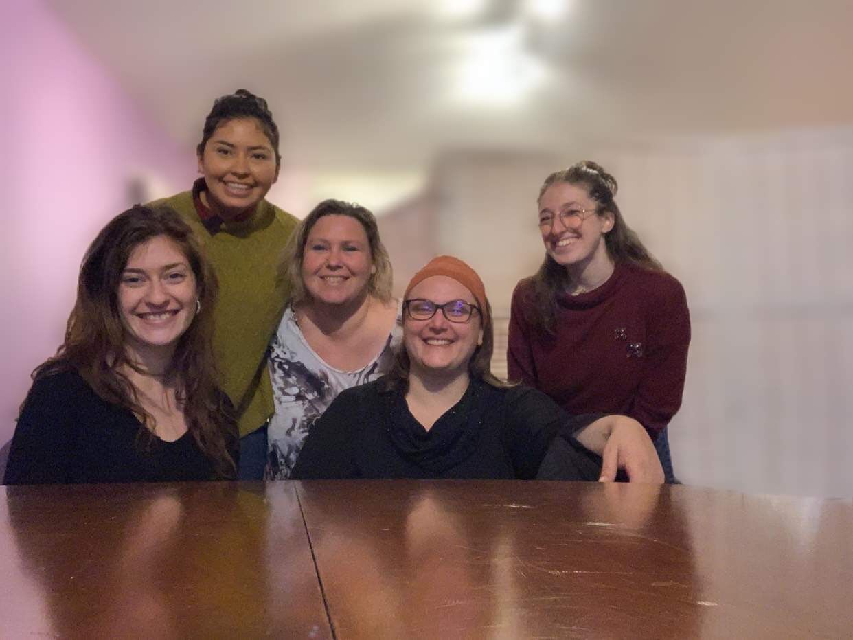 Cinq participantes souriantes autour d'une table