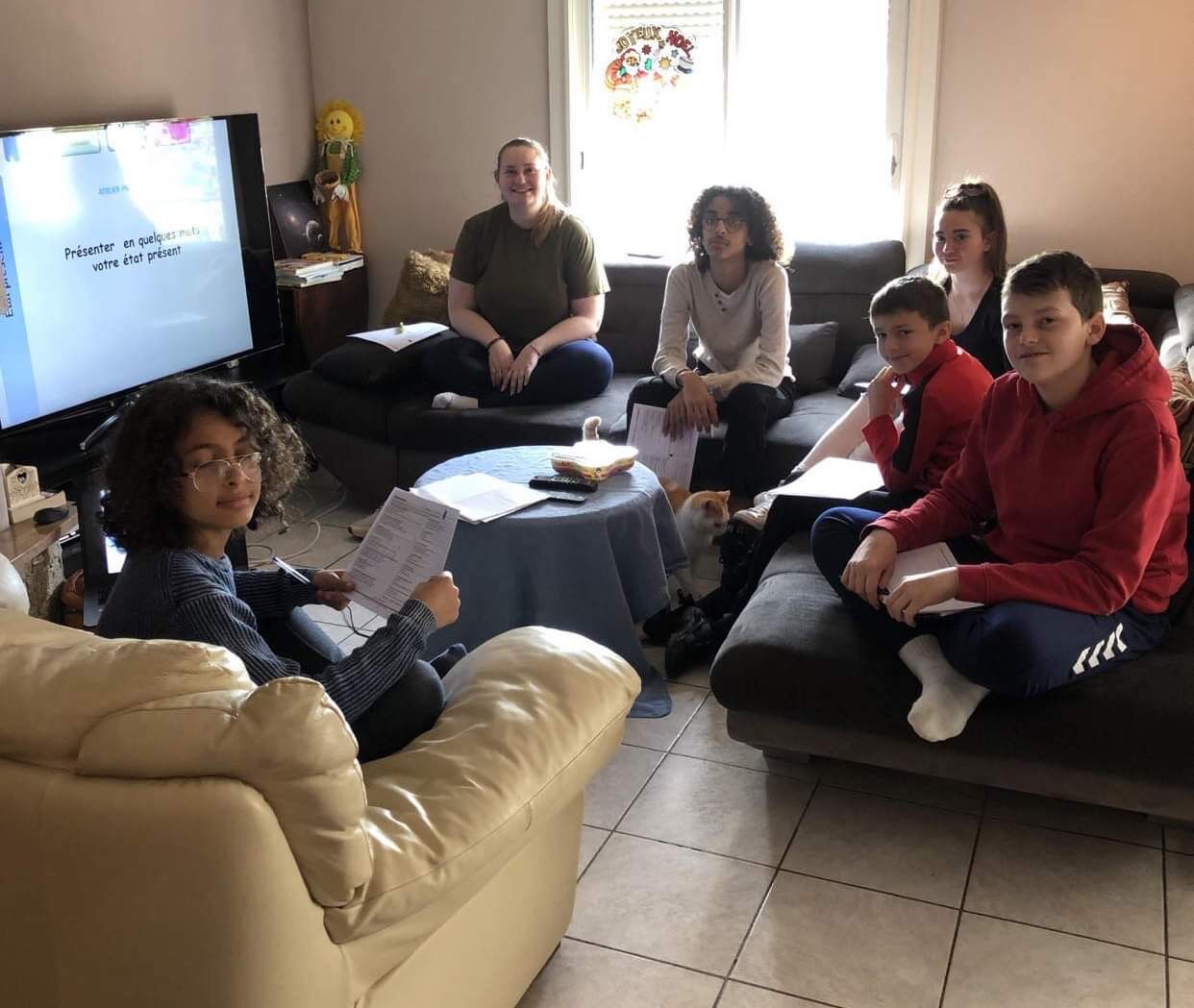 Adolescents installés dans un salon devant un écran de présentation