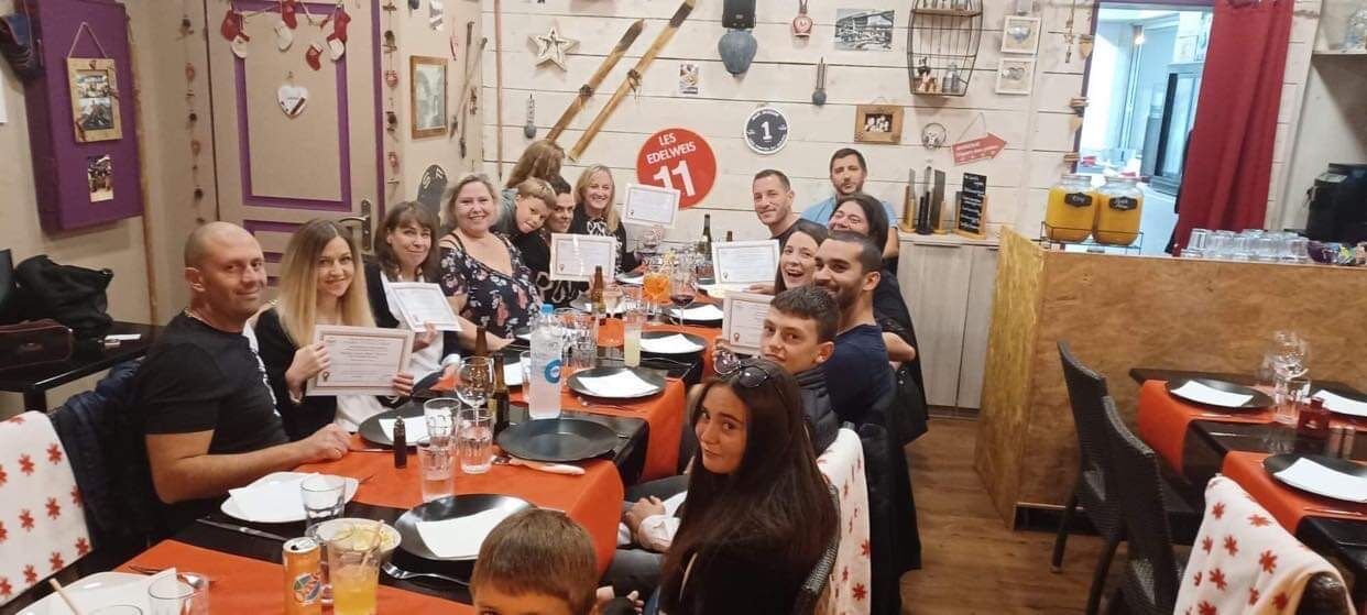 Stagiaires attablés présentant leurs attestations lors du repas de fin de formation